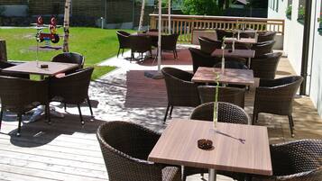An outdoor patio with wicker furniture and a red and white umbrella labeled "ESKIMO".