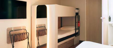 Una cama litera con un espejo, una silla y un televisor montado en la pared.