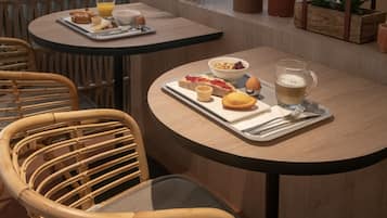 Una escena de desayuno con una bandeja de comida, una taza y un tazón sobre una mesa.