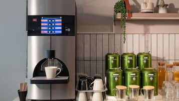 A coffee machine with a digital display, a cup holder, and a tray with cups and saucers.