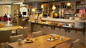 A restaurant with a bar area, seating, and a buffet with various food items. - ibis Sarlat (Sarlat-la-Canéda)