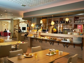 A restaurant with a bar area, seating, and a buffet with various food items. - ibis Sarlat (Sarlat-la-Canéda)