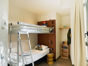 A bunk bed with a ladder, a small shelf with books, and a wooden ladder shelf. - ibis Sarlat (Sarlat-la-Canéda)