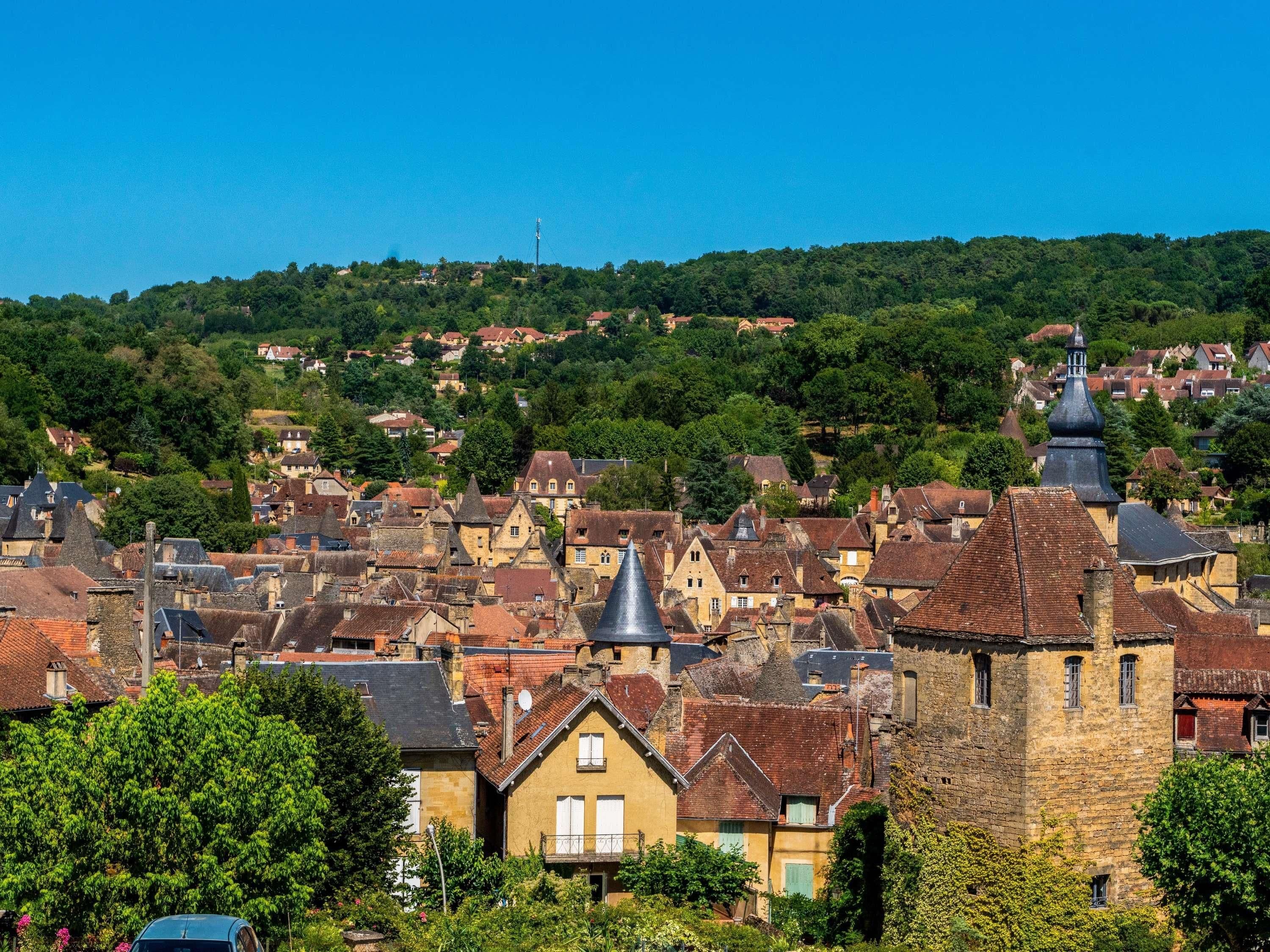 A historic town with traditional architecture, including stone buildings and a prominent church tower.