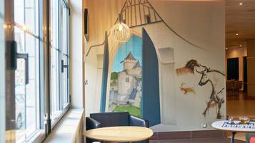 Un interior moderno con un mural, una mesa de madera y sillas de cuero negro.