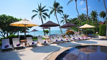 Alberca al aire libre, sombrillas en la alberca y camastros