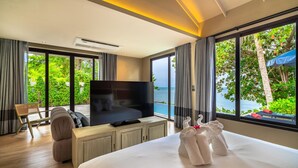 A modern hotel room with a large bed, a flat-screen TV, a wooden desk, and a view of the sea. - Mercure Koh Samui Beach Resort (Koh Samui)