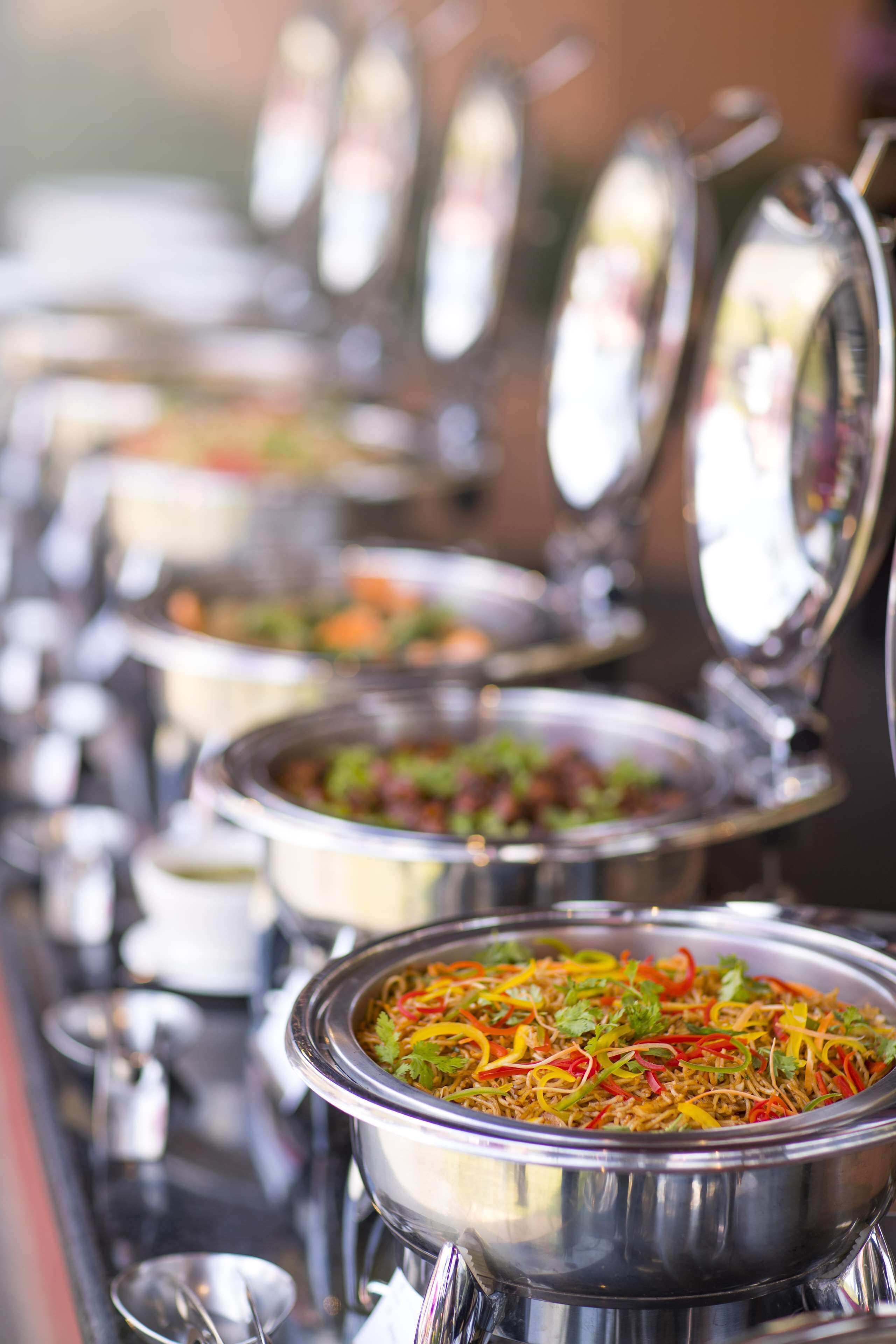 A buffet with various dishes in metal serving containers.