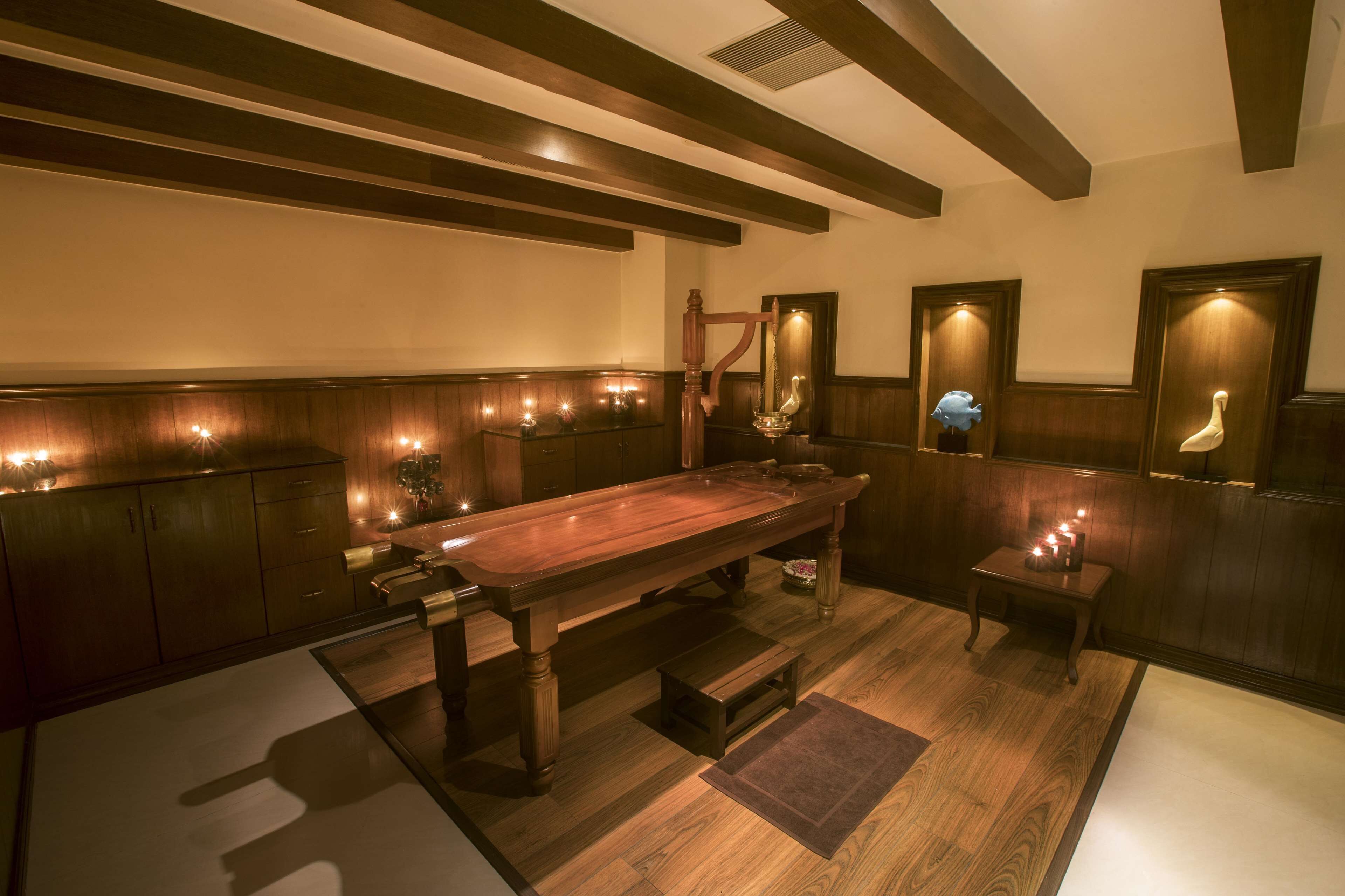 A wooden bar area with a long counter, stools, and wall-mounted lights.