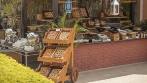 A buffet cart with various food items and a wooden display stand. - Aldovia Resort & Convention (Bengaluru)