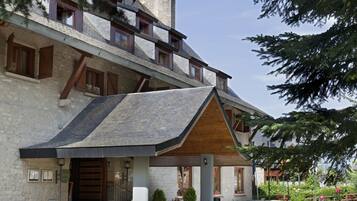 Un edificio moderno con fachada de piedra, balcones de madera y techo a dos aguas.