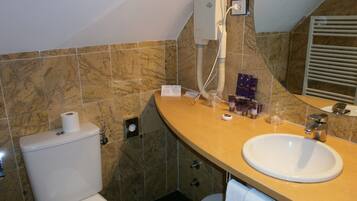 Une salle de bain avec des toilettes, un lavabo et un miroir.