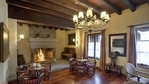 Una habitación acogedora con chimenea, muebles de madera y un candelabro.
