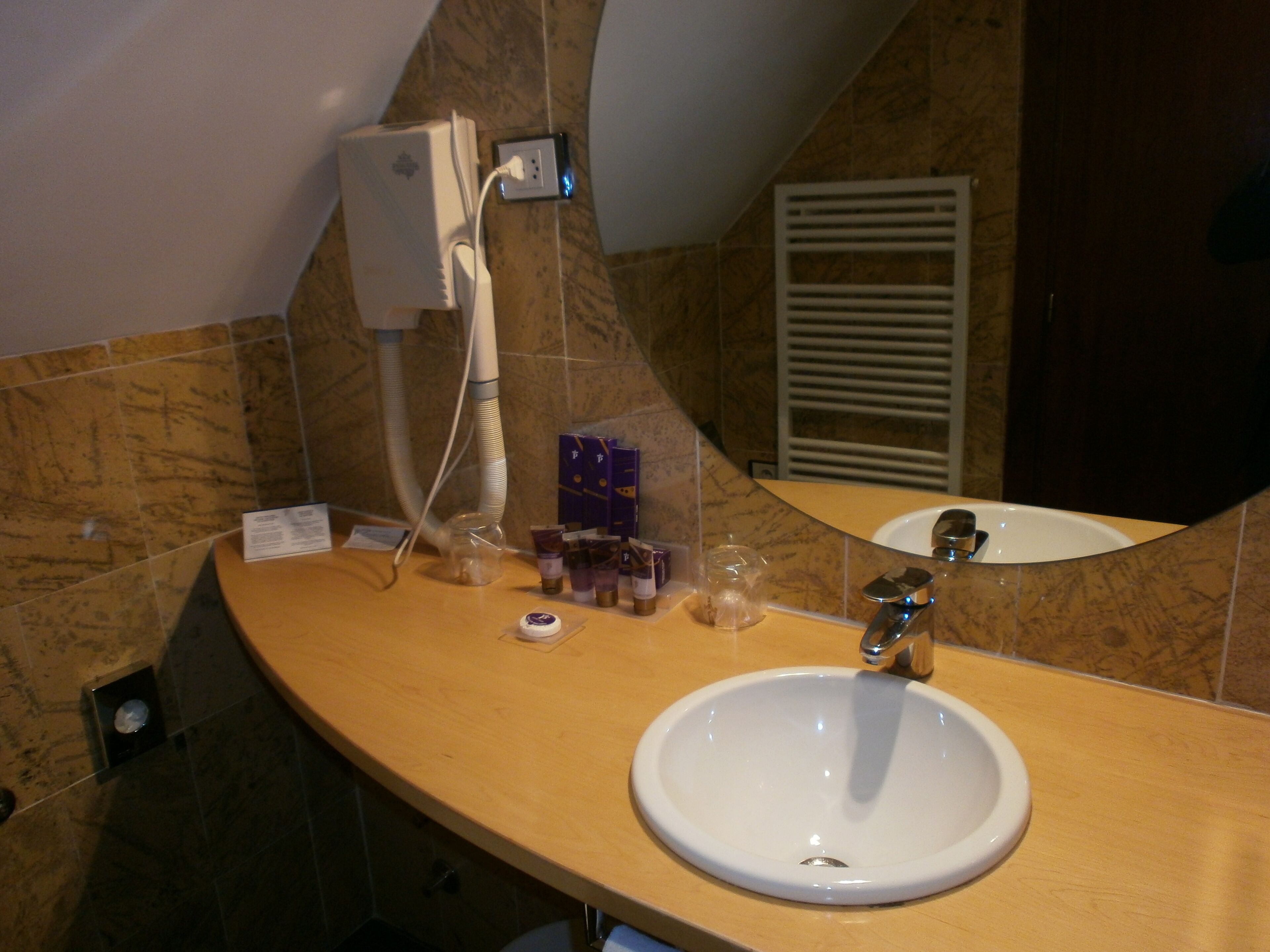 A bathroom with a white sink, a mirror, and a towel rack.