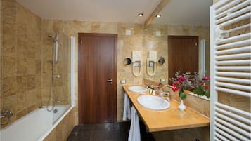 Un baño moderno con bañera, dos lavamanos, ducha y tocador con espejo.