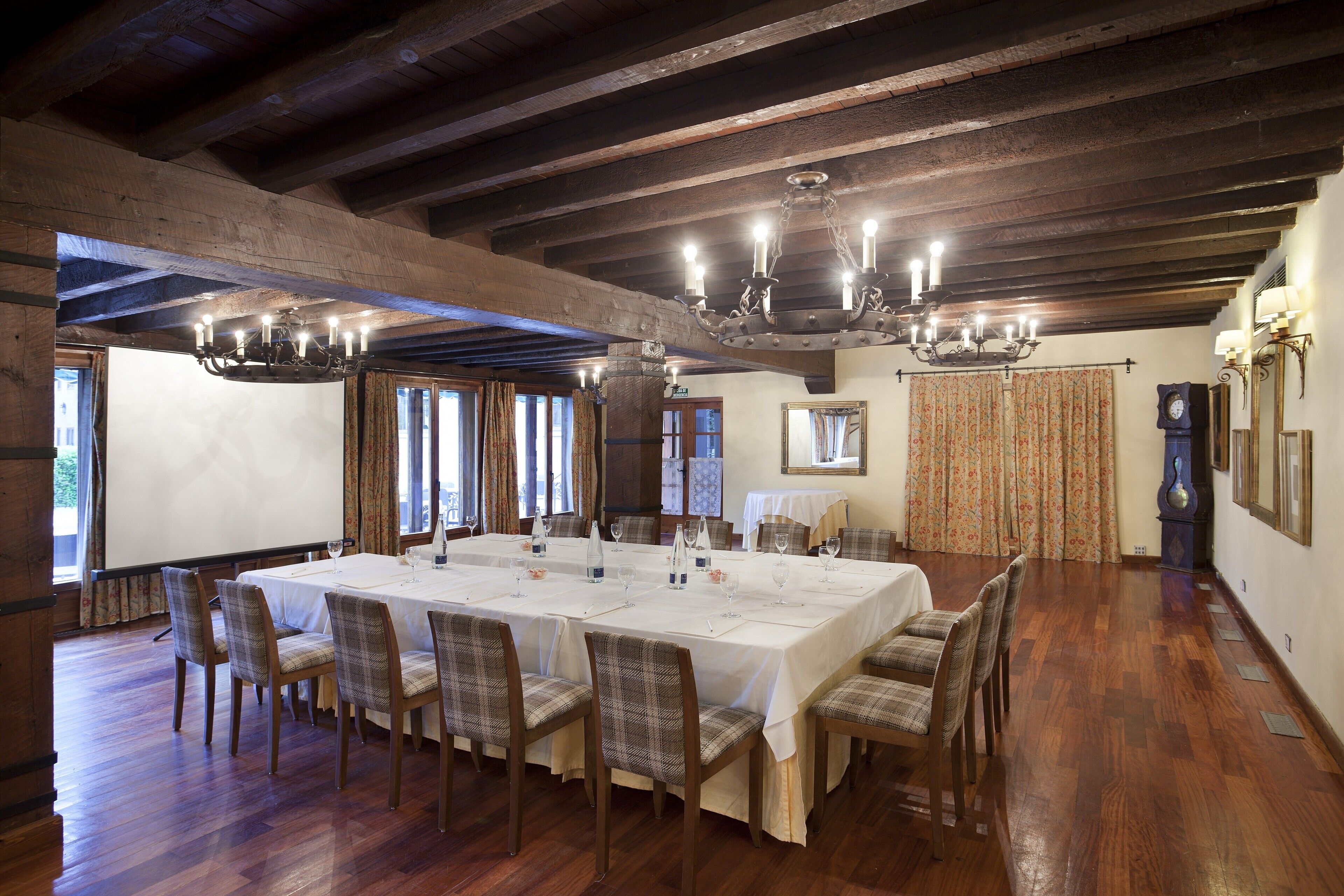 A large dining table set for a meal in a room with wooden floors and exposed beams.
