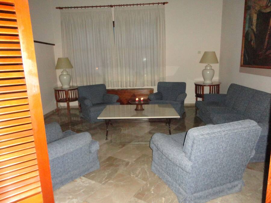 A living room with a sofa set, a coffee table, and two lamps.
