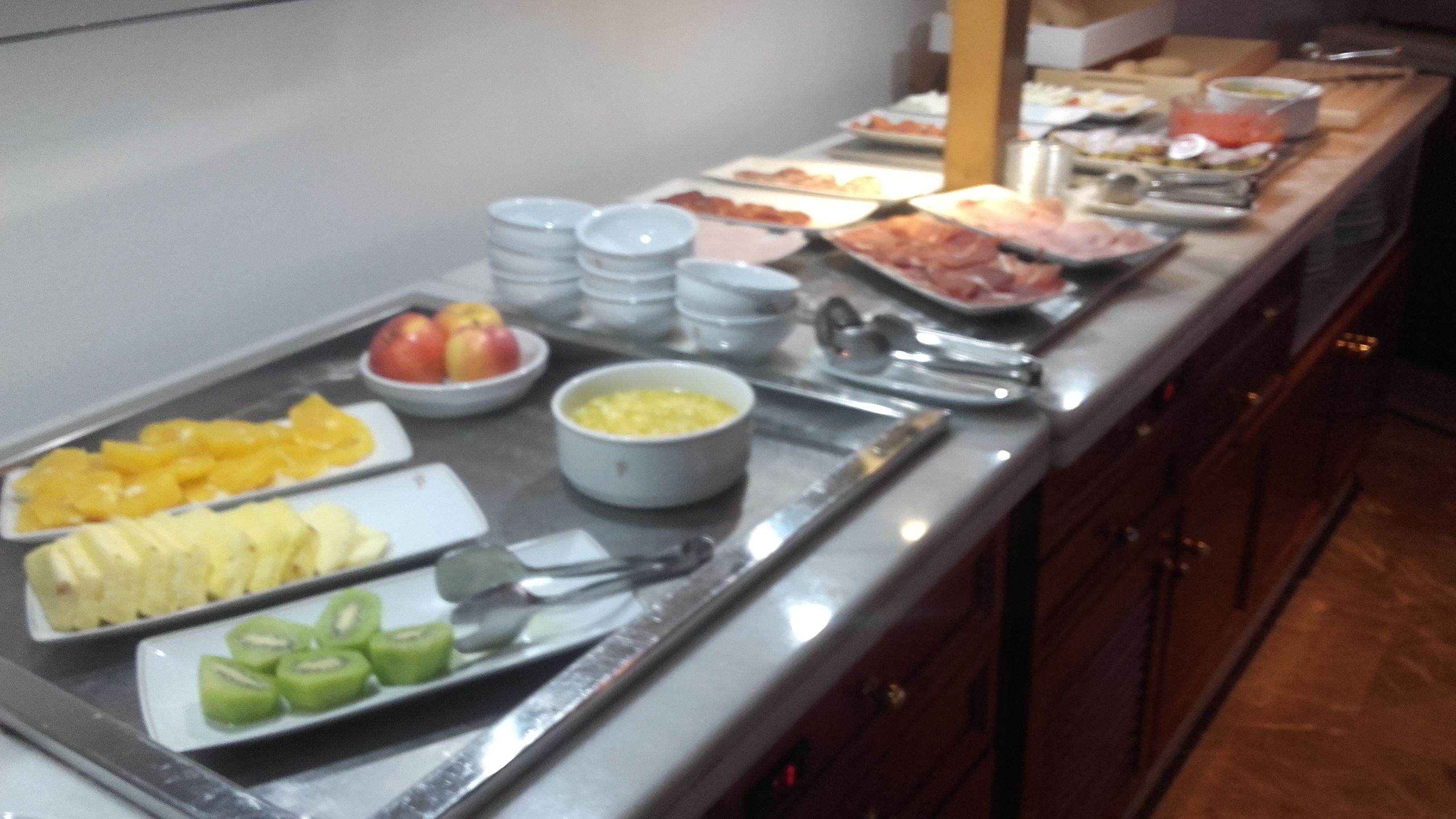 Un buffet con diverse pietanze, tra cui frutta, verdura e piatti pronti.