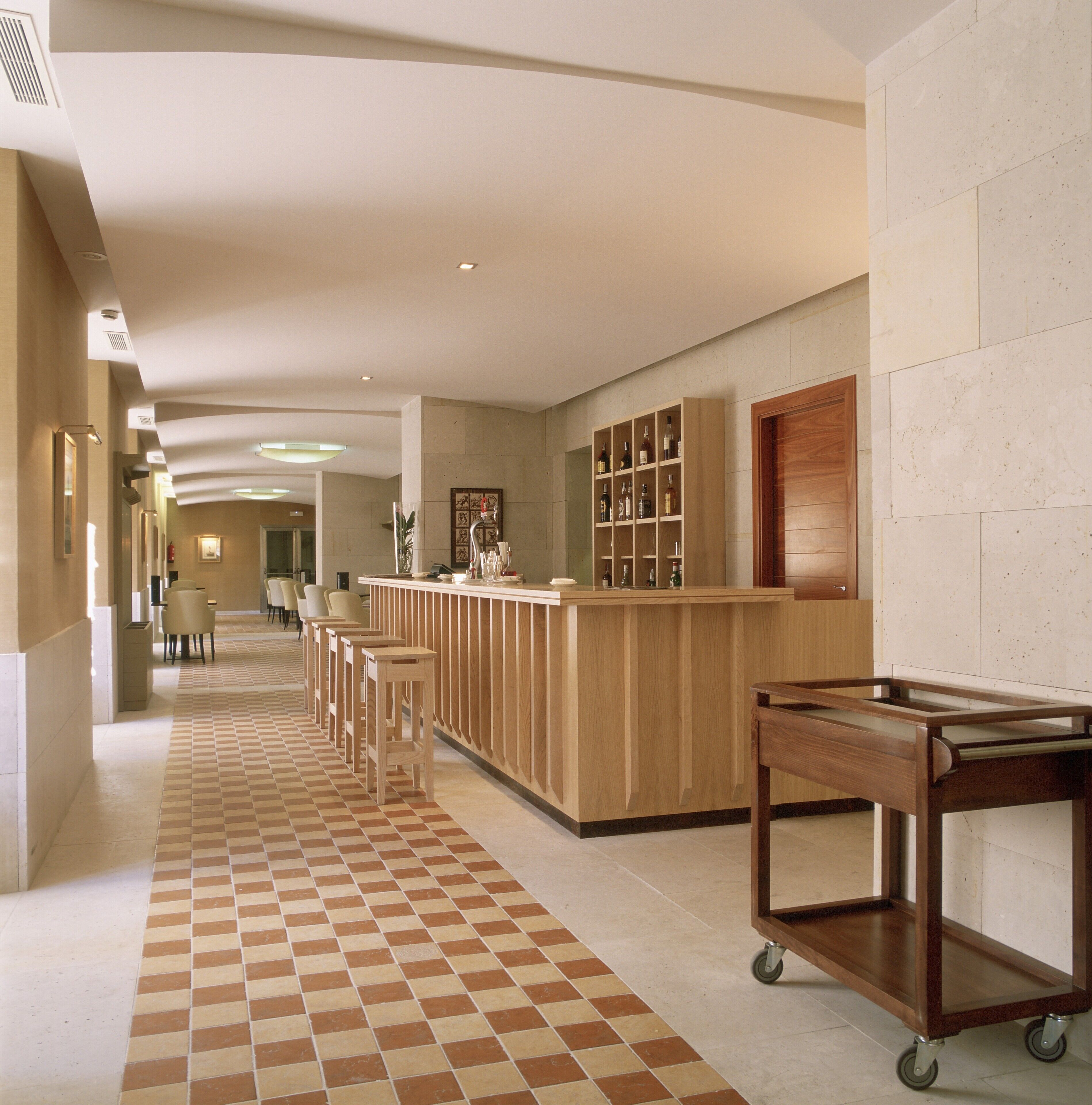 A hotel lobby with a check-in counter, seating area, and a reception desk.