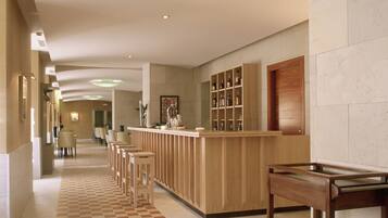 A hotel lobby with a check-in counter, seating area, and a reception desk.