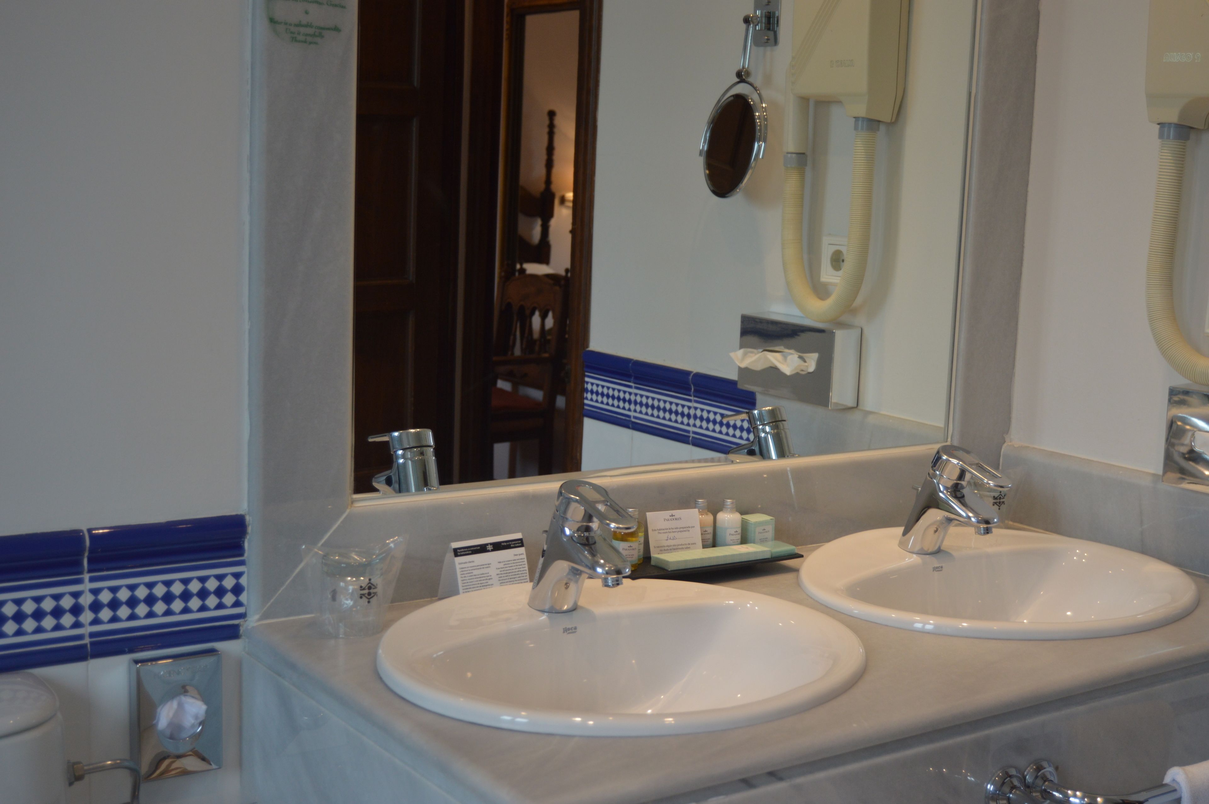 Une salle de bain avec deux lavabos, un miroir et un porte-serviettes.