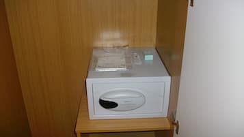 Un electrodoméstico blanco sobre una estantería de madera en una habitación con puerta de madera.