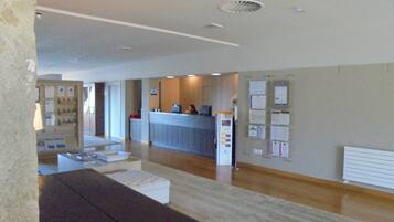 A reception area with a counter, seating, and a bulletin board.