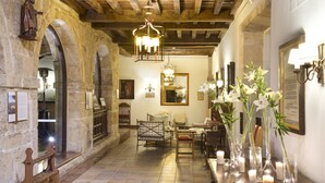 A historic interior with stone walls, wooden furniture, and a chandelier. - Parador De Cangas De Onis (Cangas de Onis)