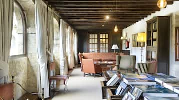 A library with bookshelves, a sofa, and a lamp.