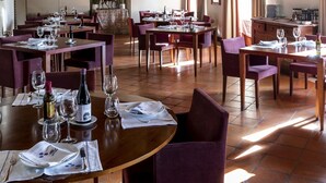A restaurant with wooden beams, multiple tables with purple chairs, and a chandelier. - Parador De Monforte De Lemos (Monforte de Lemos)
