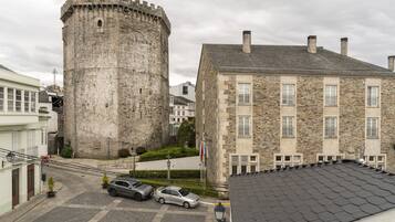 A historic stone tower and a stone building with multiple windows and a tiled roof.