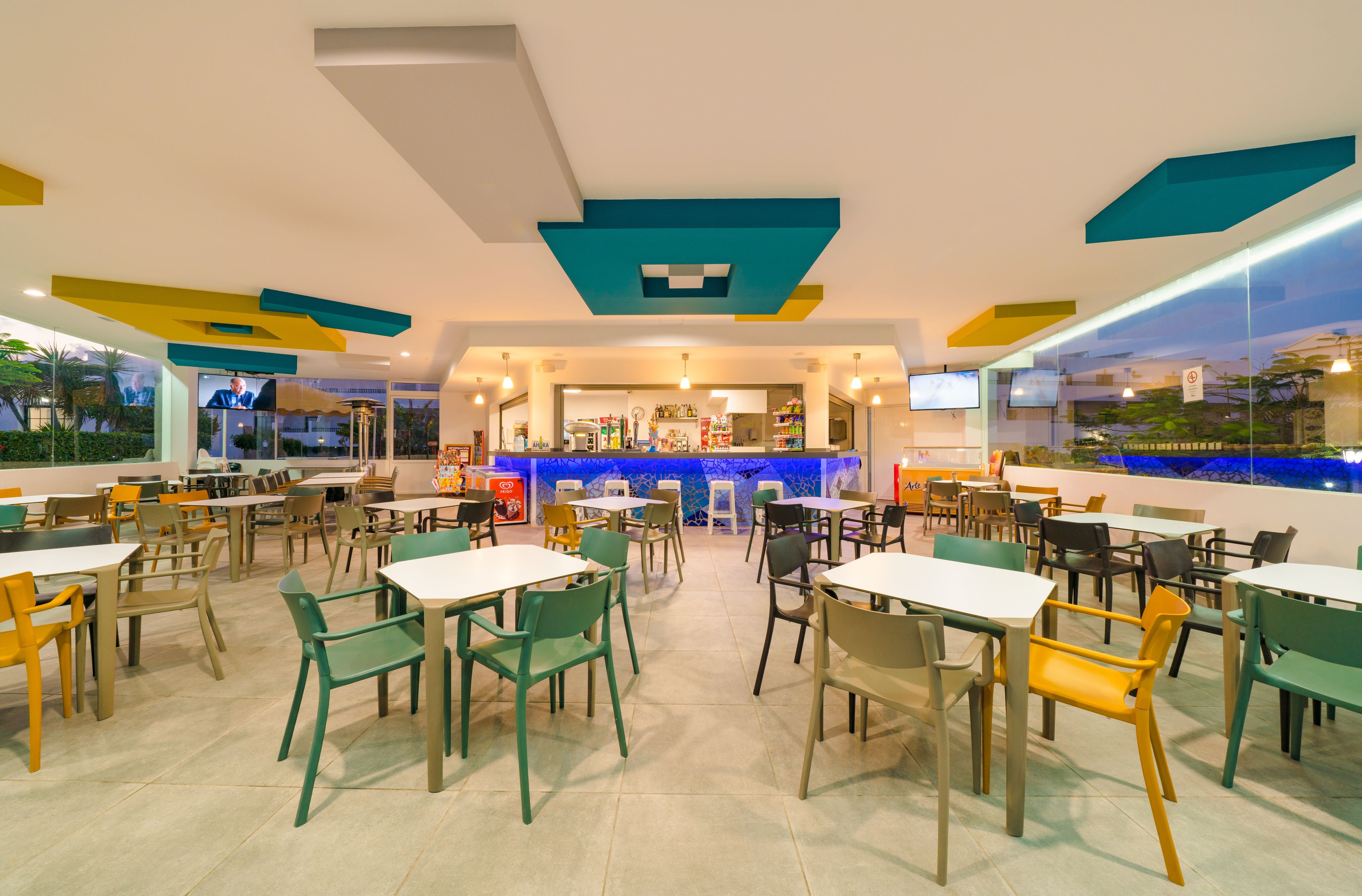 Alberca techada, alberca al aire libre y sombrillas en la alberca