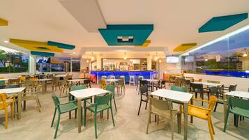 Alberca techada, alberca al aire libre y sombrillas en la alberca