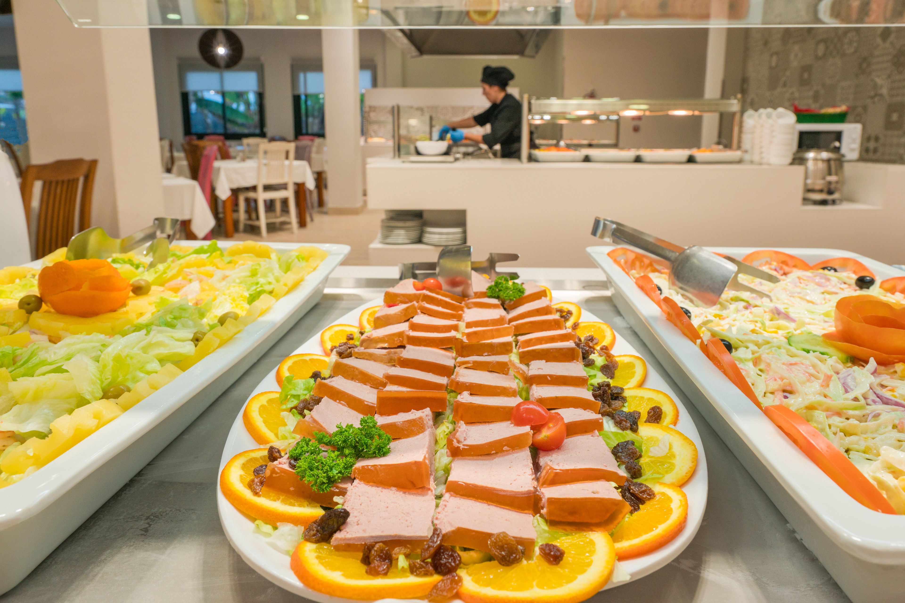 Ein reichhaltiges Buffet mit verschiedenen Speisen, darunter Aufschnitt, Obst und Salate.