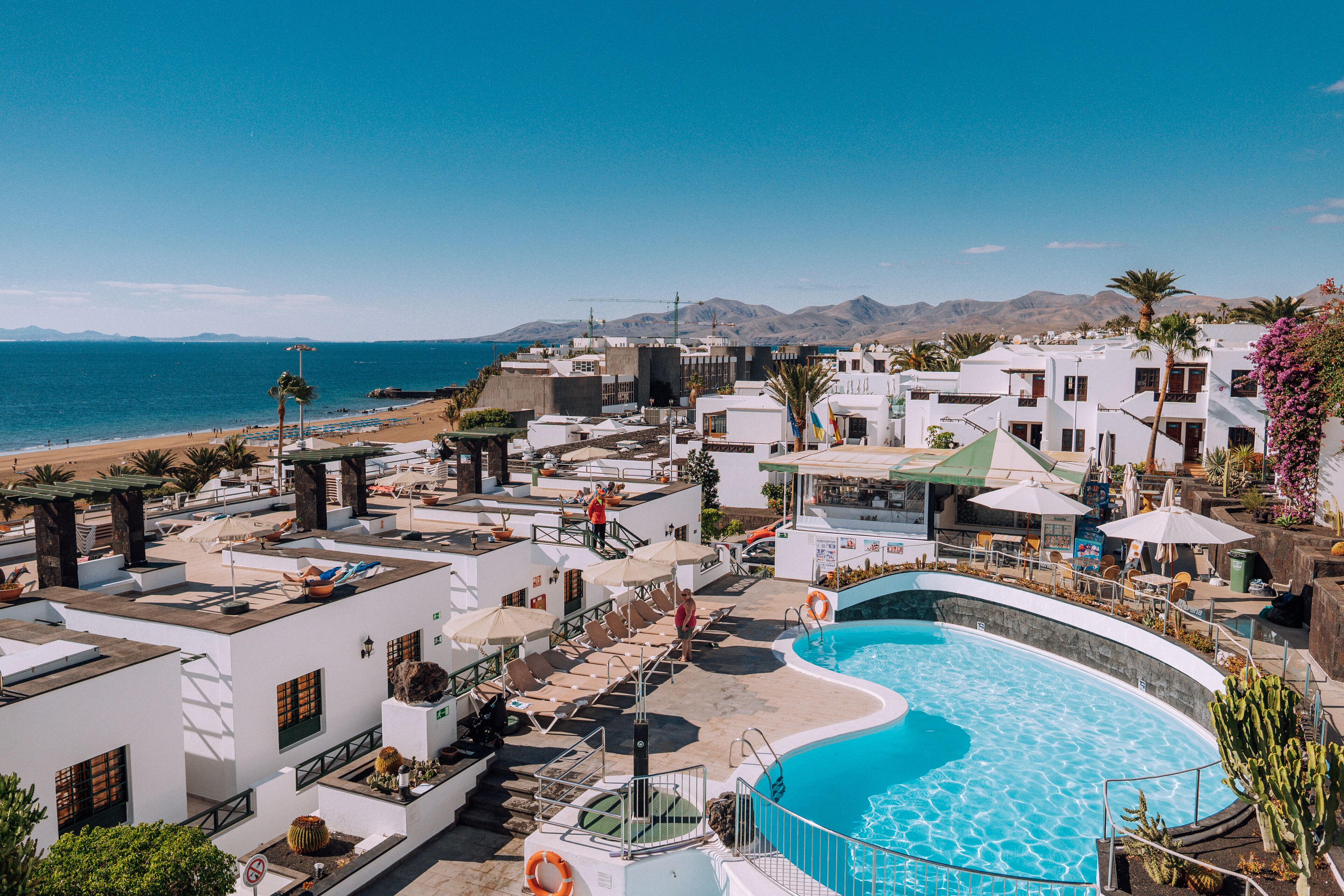 A resort with a pool, beach access, and mountain views.