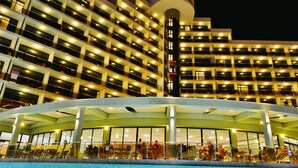 A hotel with multiple floors, a central atrium with a pool, and a circular glass structure. - Marvel (Nessebar)