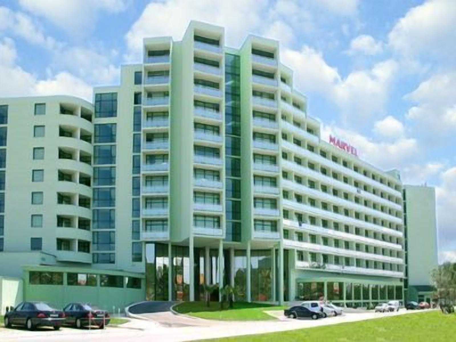 Un hotel de varios pisos con un diseño moderno, que destaca un letrero grande que dice 'MARINE'.