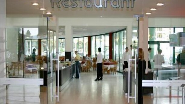A modern restaurant with a glass facade, interior seating, and a visible dining area. - Marvel (Nessebar)
