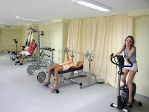 A gym with exercise equipment, including a bench press and an elliptical machine. - Marvel (Nessebar)
