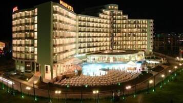 A multi-story hotel with a central atrium and a pool area.