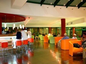 A modern lobby with orange seating areas and a glass partition. - Marvel (Nessebar)