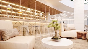 A modern interior with a bar area, seating, and a bonsai tree centerpiece. - Marvel (Nessebar)