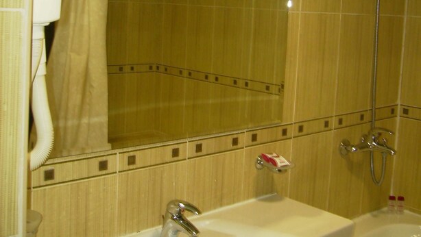 Ein Badezimmer mit zwei Waschbecken, einer Dusche und einem Spiegel.