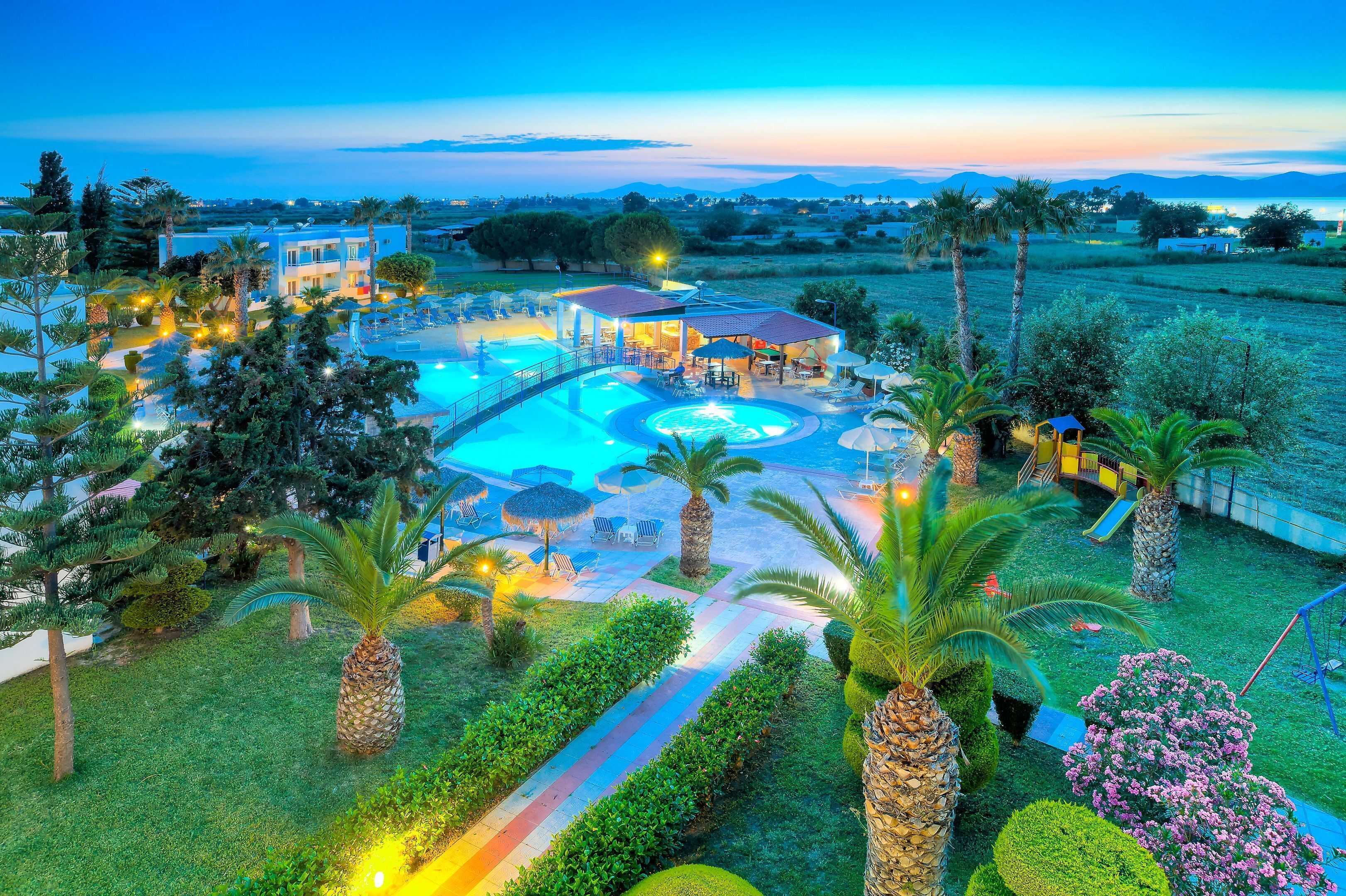 A resort with a swimming pool, outdoor seating, and lush landscaping.