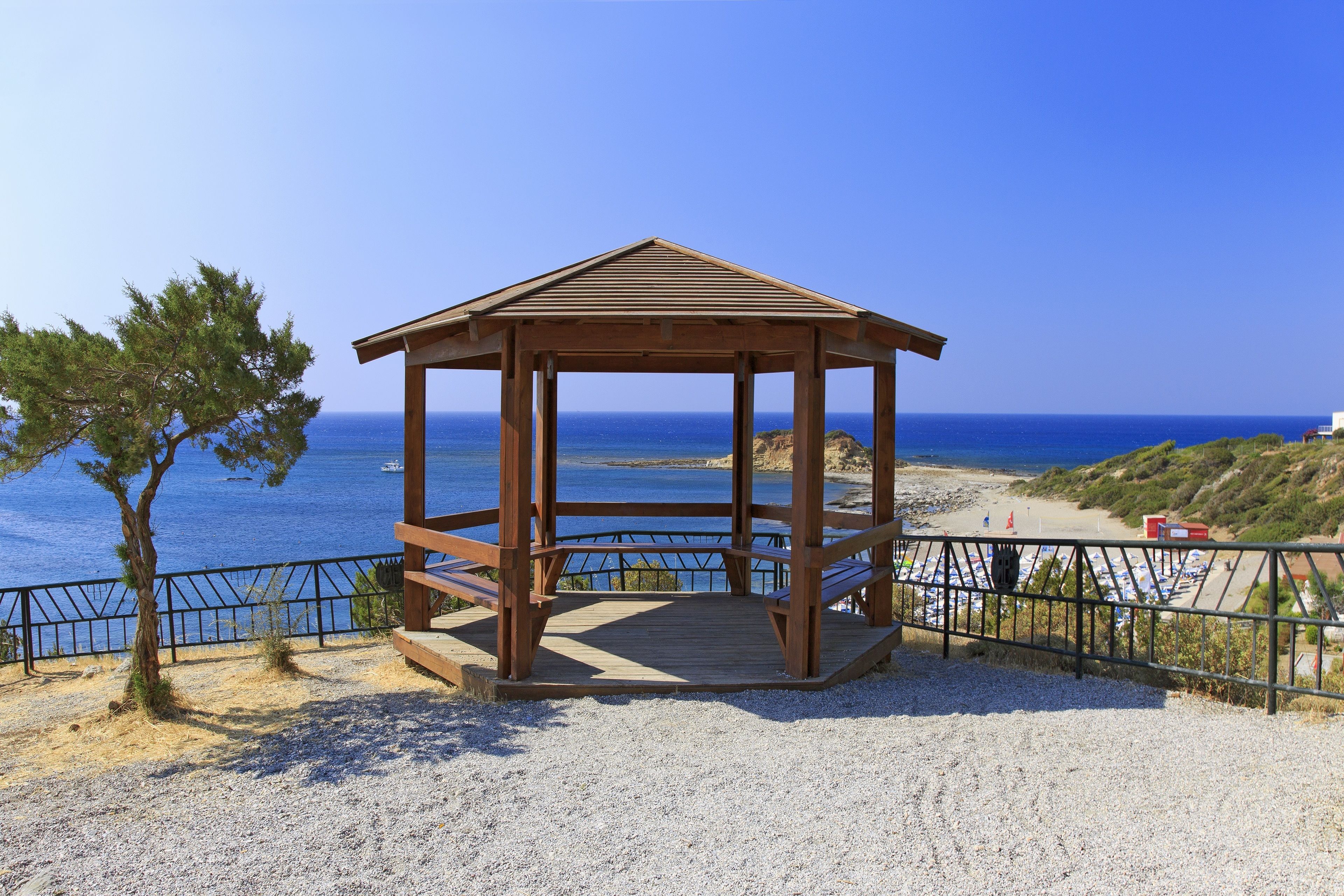 Ein hölzernes Pavillon mit freiem Blick auf das Meer und den Strand im Hintergrund.