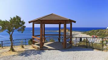 Ein hölzernes Pavillon mit freiem Blick auf das Meer und den Strand im Hintergrund.