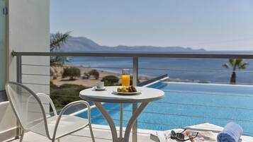 A balcony with a table, chairs, a newspaper, and a towel.