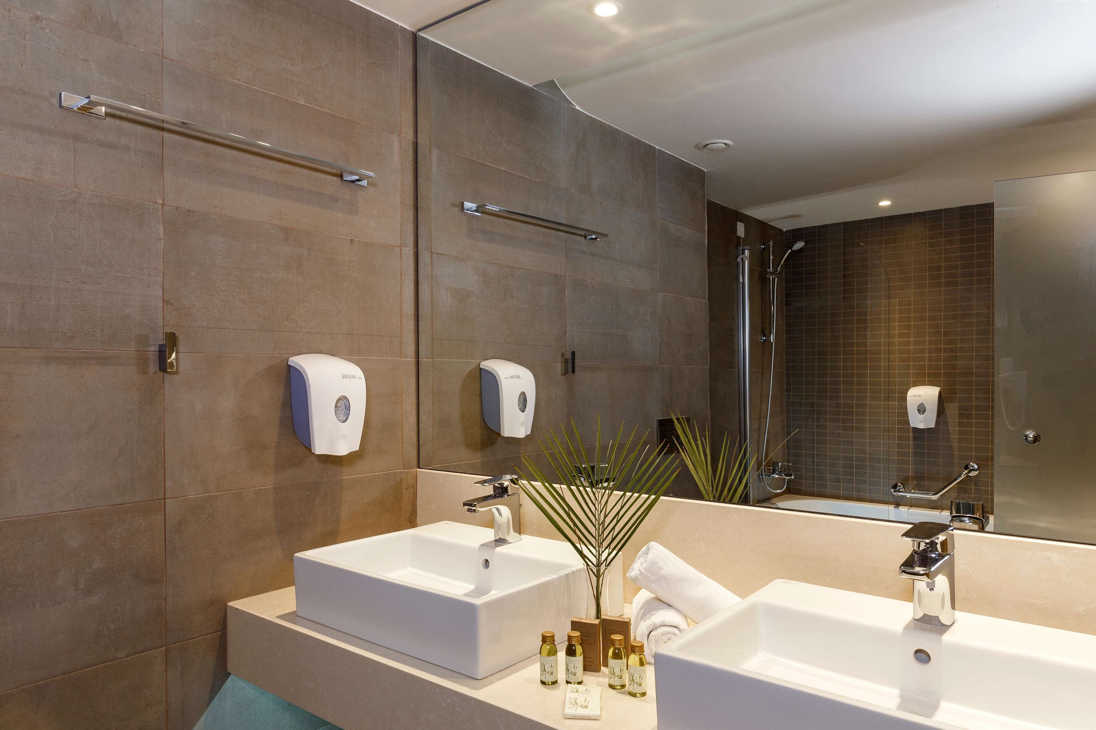 Une salle de bain moderne avec deux lavabos, des porte-serviettes et un espace douche.