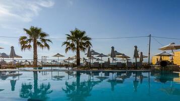 Een buitenzwembad, parasols voor strand/zwembad