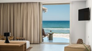 Una habitación con un amplio ventanal que ofrece vistas a la playa y al océano.